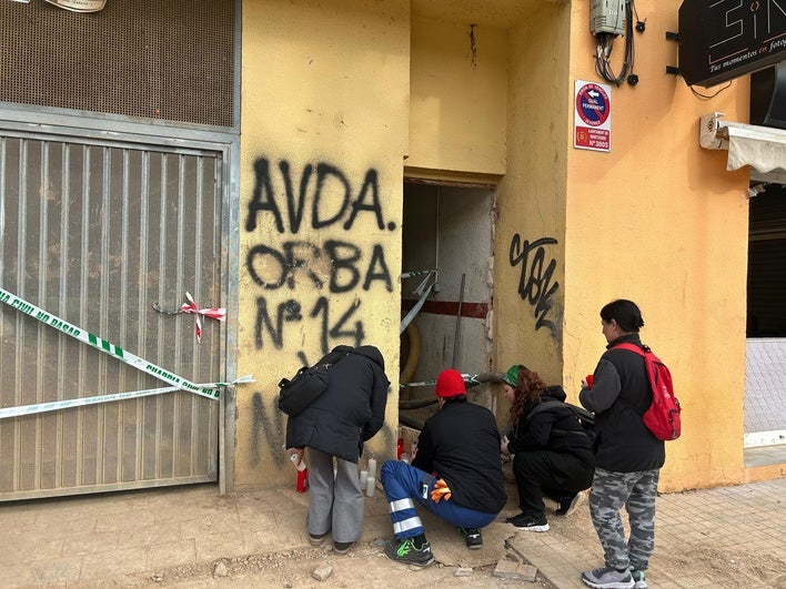 Varias personas colocan velas ante el edificio en el que falleció un trabajador por el derrumbe en Benetússer.