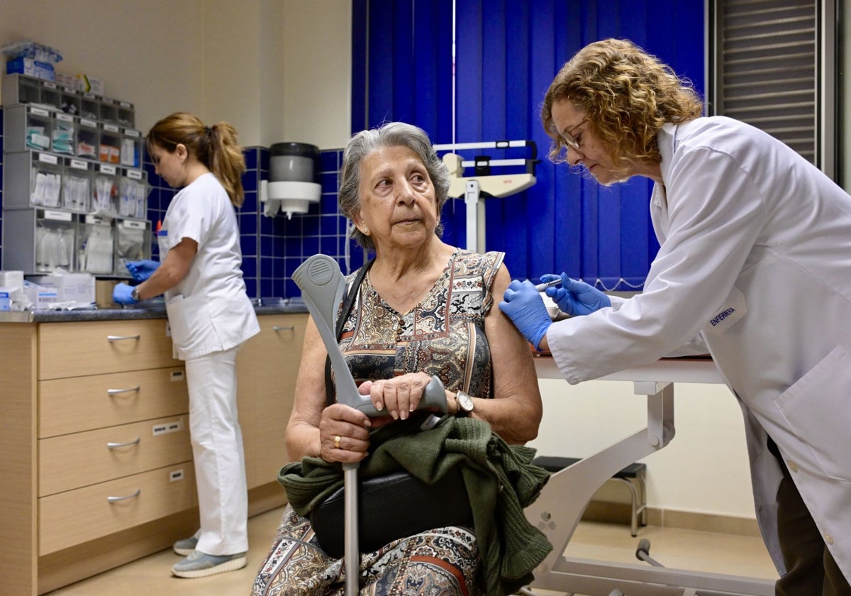 Vacunación a una mujer mayor en un centro de salud.