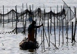 Un pescador faena en el lago.