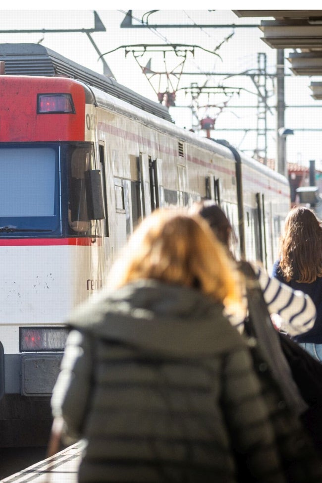 TRes mujeres se disponen a coger un tren de Cercanias.