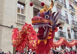 Varios participantes sostienen un dragón típico de la cultura china.