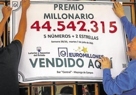 Dos afortunados ganadores del Euromillón cuelgan el cartel con el premio obtenido. Imagen de archivo.