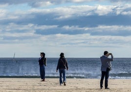 Unos paseantes en la playa de la Malvarrosa.