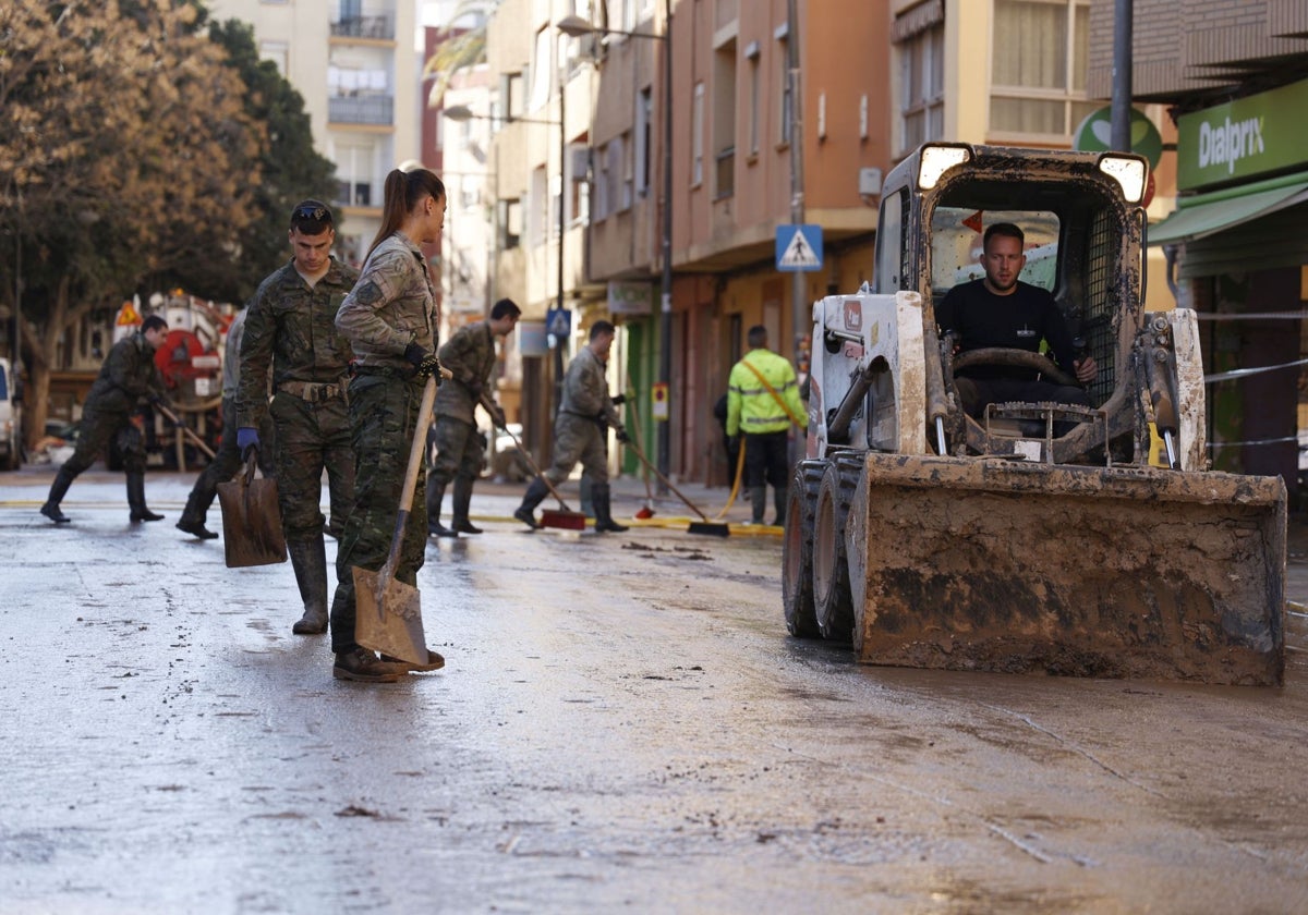 Un grupo de militares limpia una calle de Paiporta.