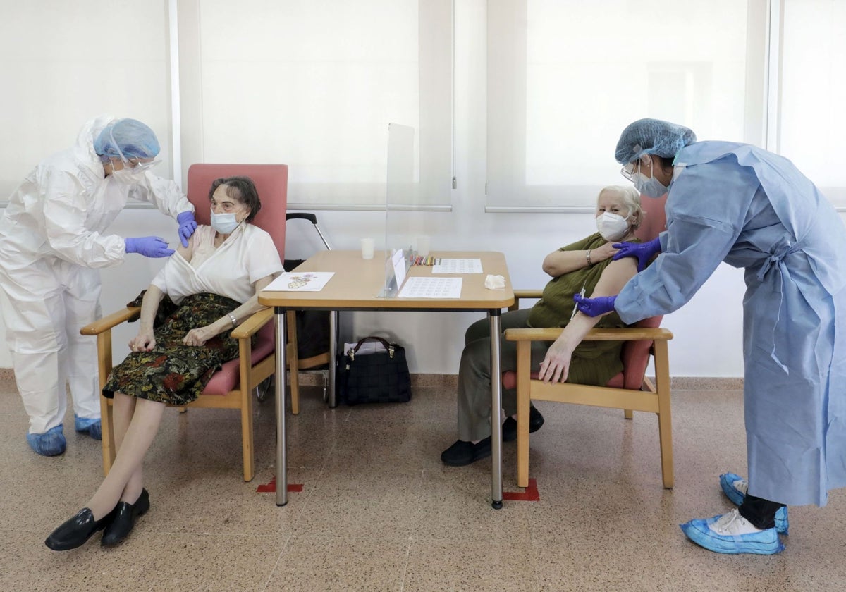 Dos mujeres mayores reciben la vacuna contra el coronavirus, en una residencia de Valencia.