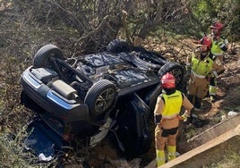 Bomberos de Castellón junto al vehículo en el que viajaban las dos mujeres fallecidas.