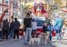 Unos perros pasean con su dueña, mientras visitan una falla en Ruzafa.