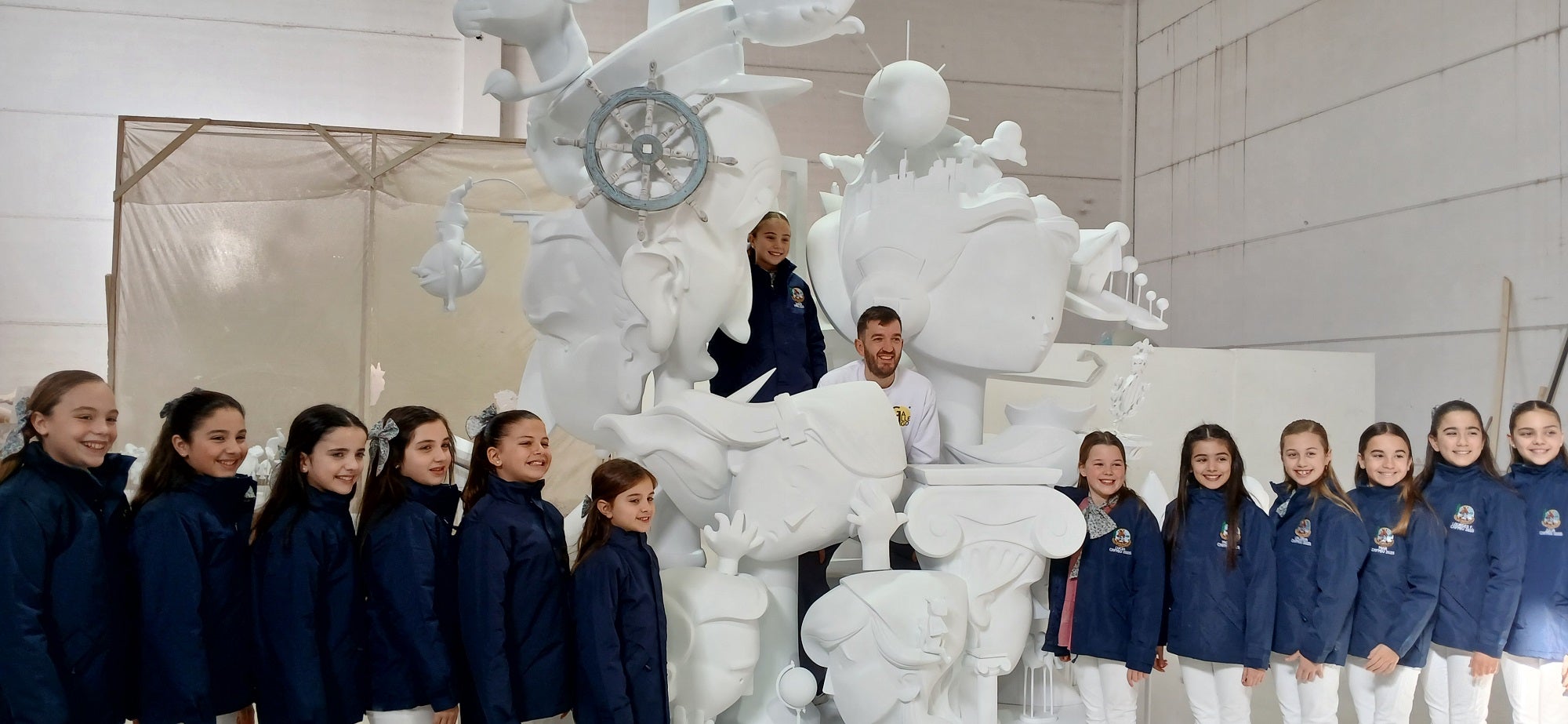 Lucía García, su corte de honor y el artista fallero, junto al momumento.