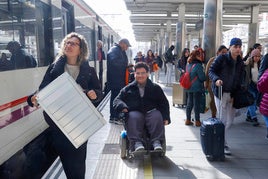 Álvaro junto a su madre, en la estación del Nord de Valencia donde acude a diario.