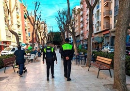 Dos policías locales de patrulla por una avenida de Mislata.