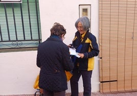 Mª Carmen Climent entrega una notificación a una vecina.