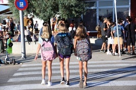 Varios niños en la entrada de un colegio.