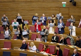 Diputados socialistas exhiben pancartas en la sesión plenaria de este jueves.