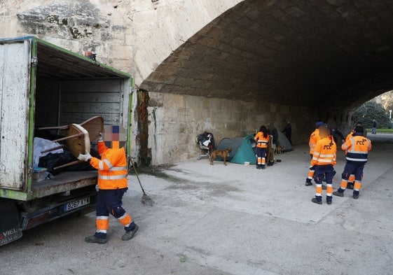 Brigadas de limpieza, retiran material acumulado en el puente del Real, en el jardín del Turia.