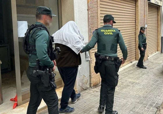 El arrestado por mandar amenazas de bomba, escoltado por la Guardia Civil tras el registro de su domicilio.