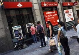 Varias personas hacen cola en un banco de Santander.