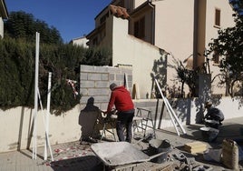 Dos trabajadores levantan un muro en una casa particular de Paiporta.