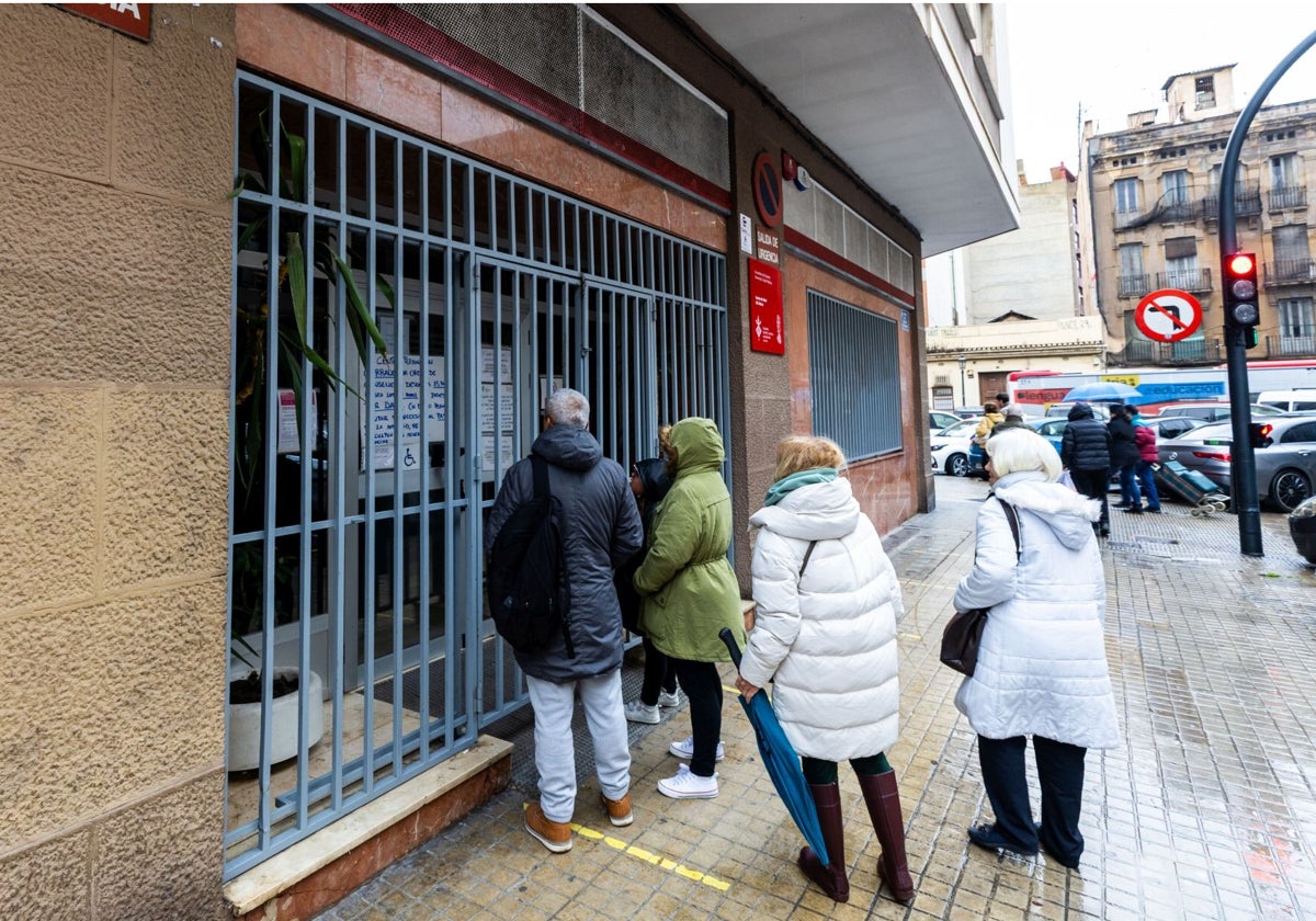 Varias personas leen el cartel de cerrado de un centro de salud en Valencia este miércoles.