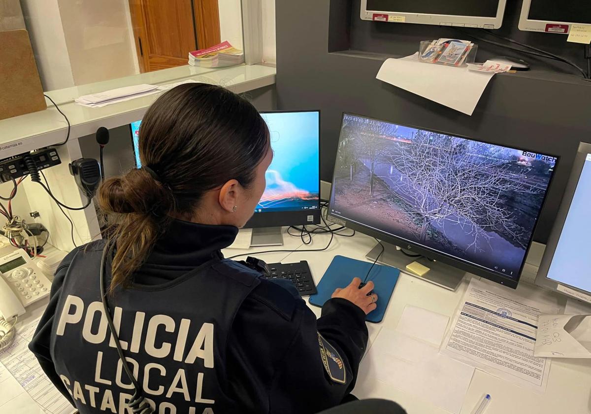 Una agenda de la Policía Local observa las imágenes del barranco del Poyo en Catarroja.