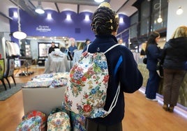 Una joven fallera, ya peinada, con una mochila inspirada en la indumentria valenciana.