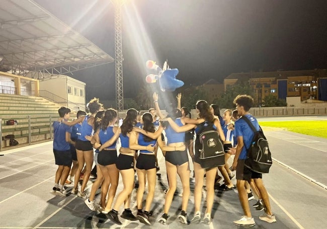 Los jóvenes atletas del club Atletismo Diànium hacen una piña tras terminar de sus entrenamientos.