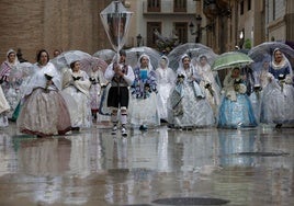 Falleras desfilan bajo la lluvia en la Ofrenda de este año.