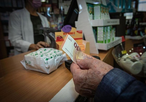 Un cliente paga en efectivo en una farmacia.