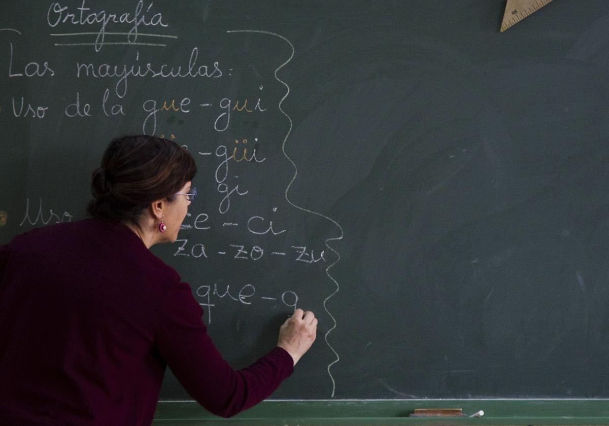 Una maestra escribe en la pizarra en un aula en España, en una imagen de archivo.