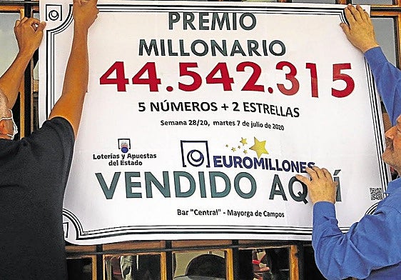 Dos afortunados ganadores del Euromillón cuelgan el cartel con el premio obtenido, en una imagen de archivo.