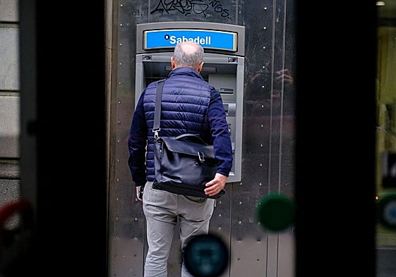 Hombre saca dinero de un cajero en una imagen de archivo