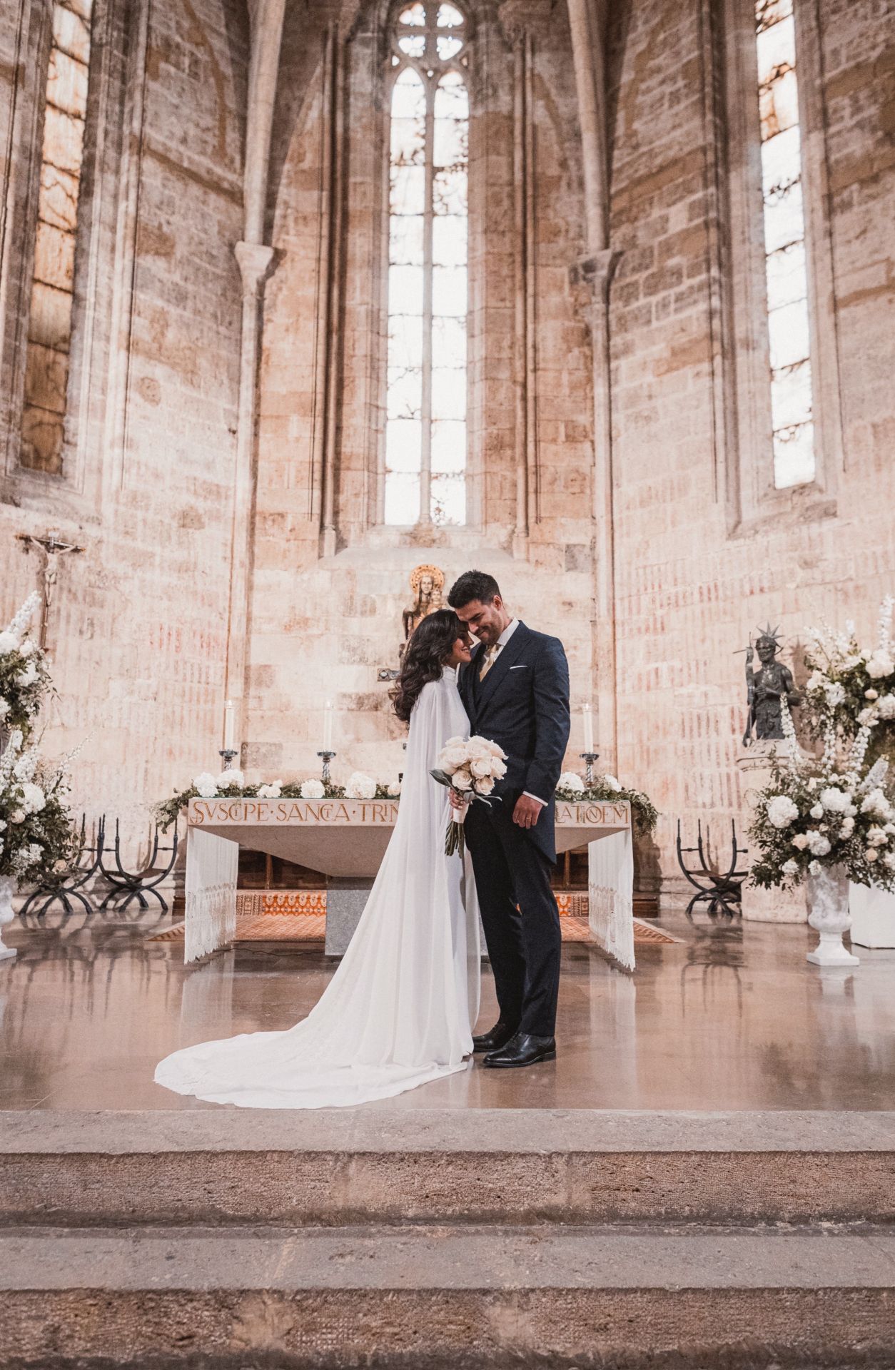 La pareja tras la boda en San Juan del Hospital, decorada con flores blancas.