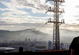 Una persona observa el cableado con el que red eléctrica transporta la energía sobre la ciudad de Bilbao