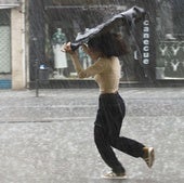 Una mujer se protege de la lluvia en una imagen de archivo.