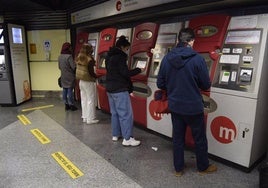 Gente sacando el bono del metro en una estación.