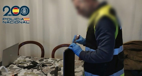 Uno de los agentes manipunlando un dispositivo de almacenamiento.
