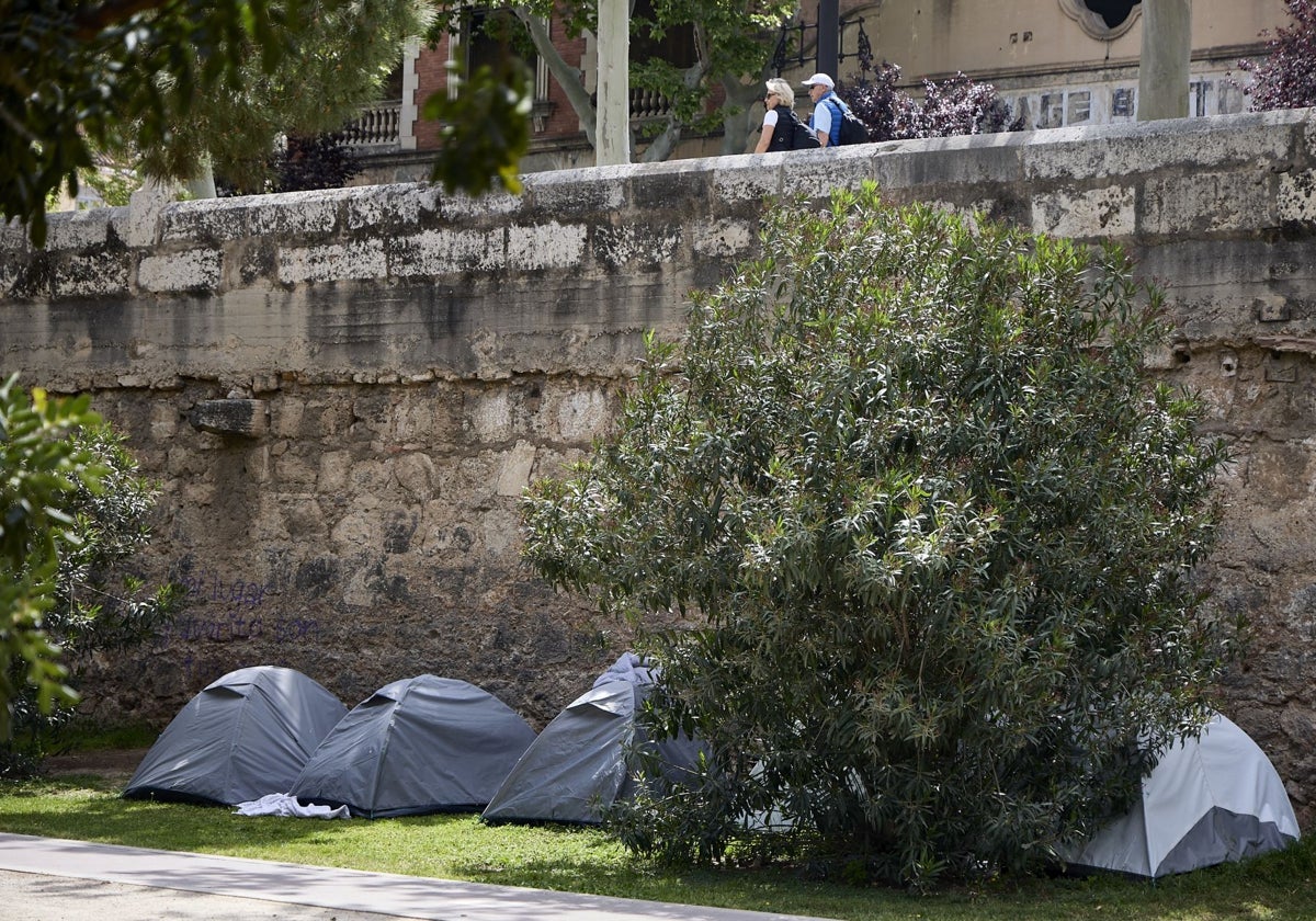 Un asentamiento de cinco tiendas de campaña en uno de los pretiles del antiguo cauce.