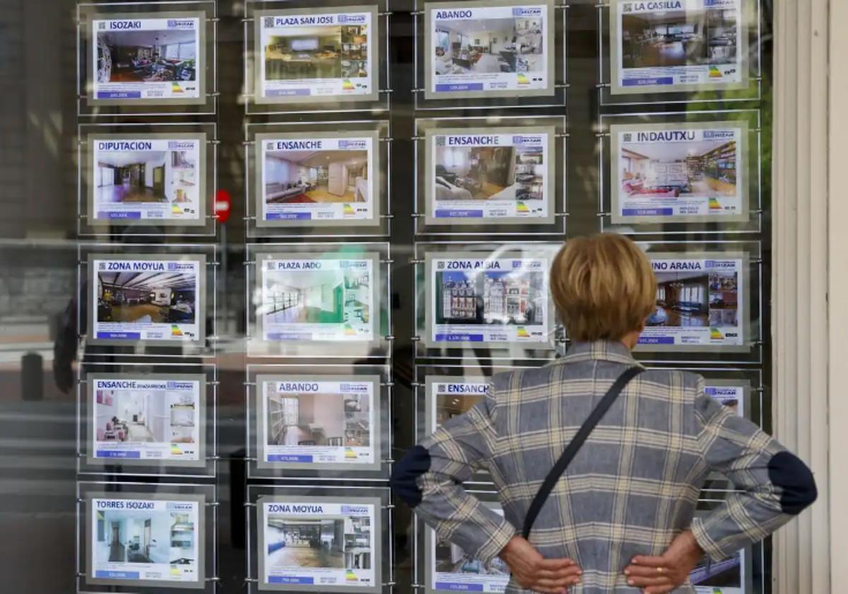 Una mujer mira ofertas en una inmobiliaria.