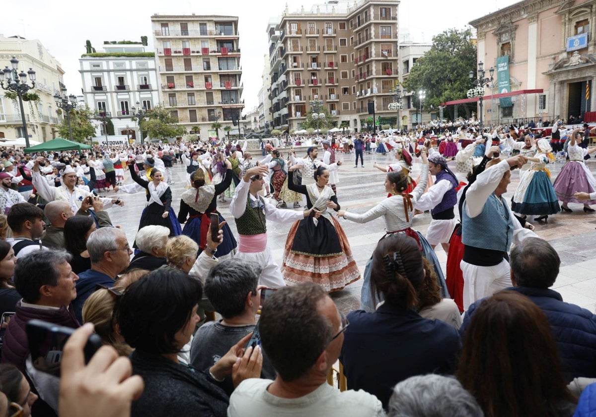 Imagen principal - Dansà de los grupos de pueblos, calles engalanadas para la fiesta de la Virgen y decoraciones florales.