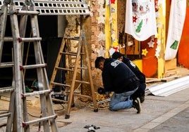 Dos empleados trabajan en las labores de reparación de un comercio afectado en Paiporta.