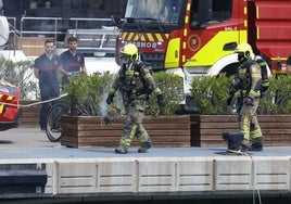Dos de los bomberos que han intervenido este lunes en el puerto de Valencia.