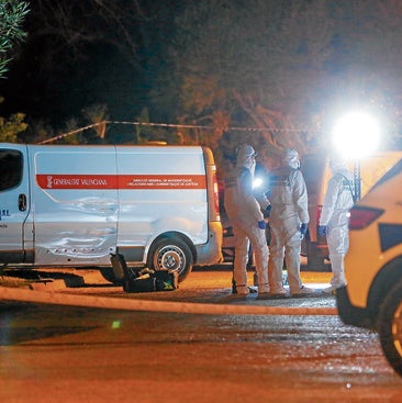 Agentes del Servicio de Criminalística, el 27 de febrero por la noche, junto al furgón del retén fúnebre.