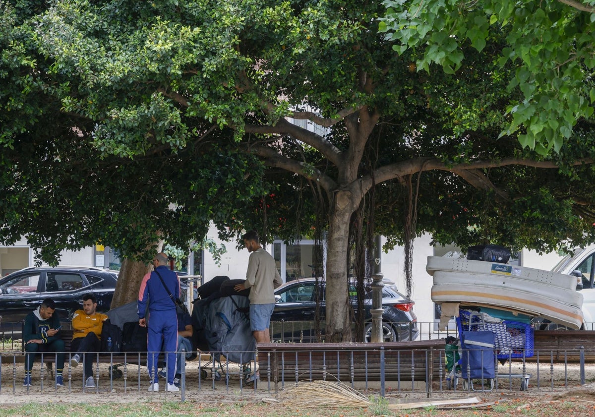 Imagen principal - Nave desalojada con vigilancia policial y personas con colchones, en el jardín de la calle Filipinas.