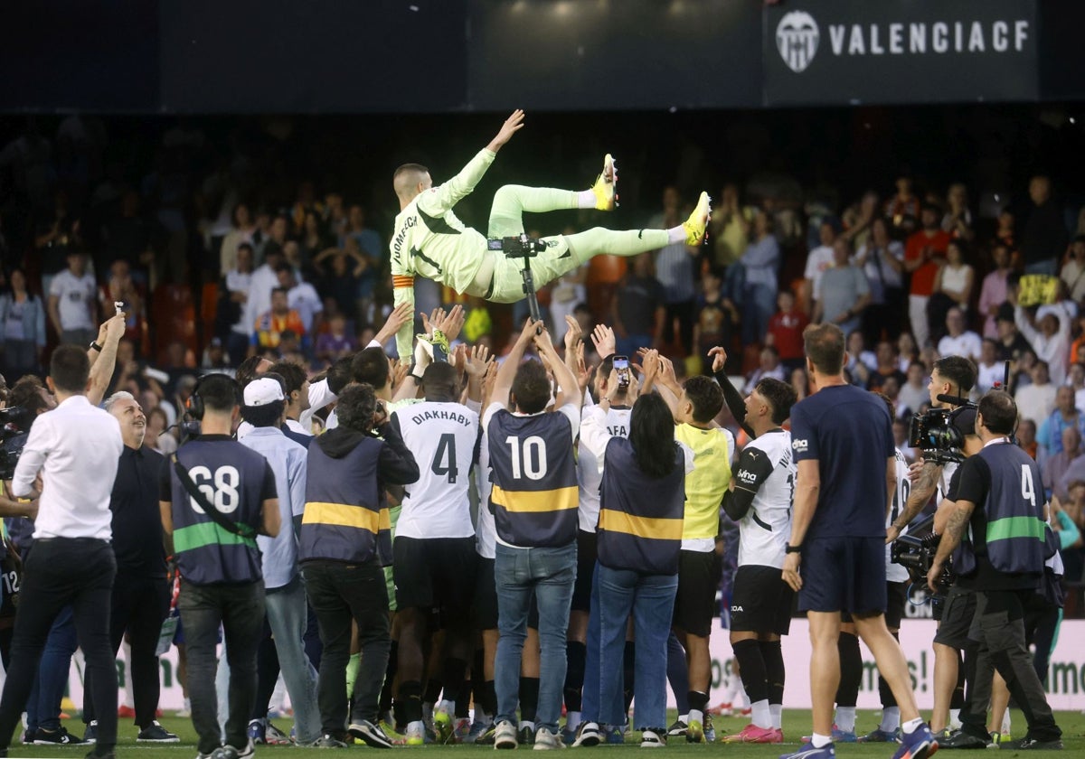 Jaume Doménech es manteado por sus compañeros sobre el césped de Mestalla.
