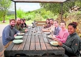 Algunos de los huéspedes, comiendo juntos en el exterior del coliving de Culla.