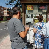 Varias personas hacen cola para comprar un décimo de la ONCE.