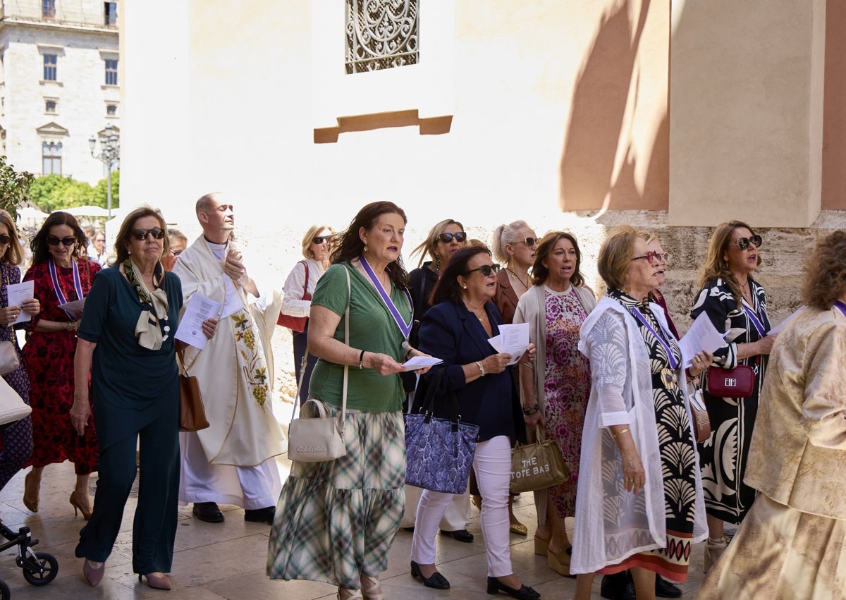 Imagen secundaria 1 - Marisa, a la izquierda, viendo pasar a la camarera de la Virgen y la corte de honor.