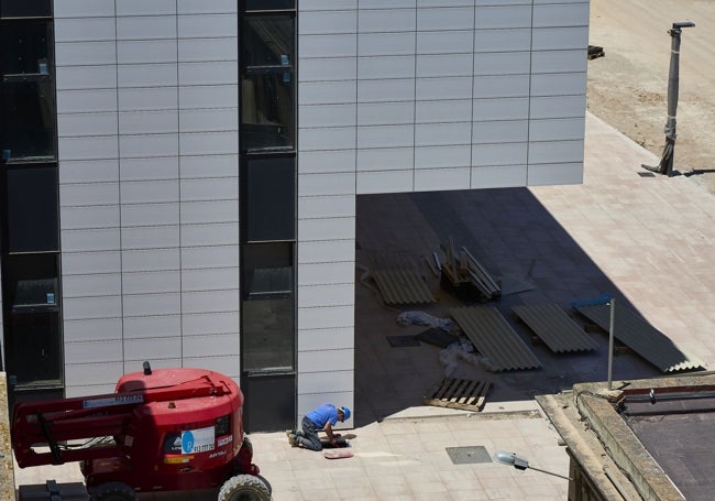 Fachada del nuevo edificio del Militar, con un obrero acondicionando en suelo.