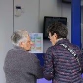 Administración de lotería junto al cartel de un premio millonario.