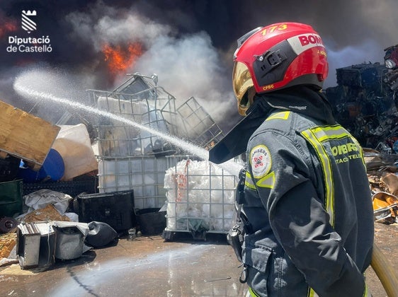 Un bombero, en las labores de extinción del fuego en el desguace.