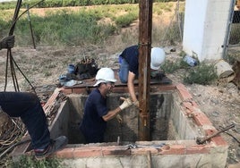 Reparación. Un equipo de especialistas extrae, con ayuda de una grúa, la tubería y la bomba de impulsión de un pozo de riego.